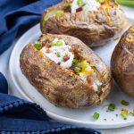 Serve baked potatoes with cheese, chives, and bacon.