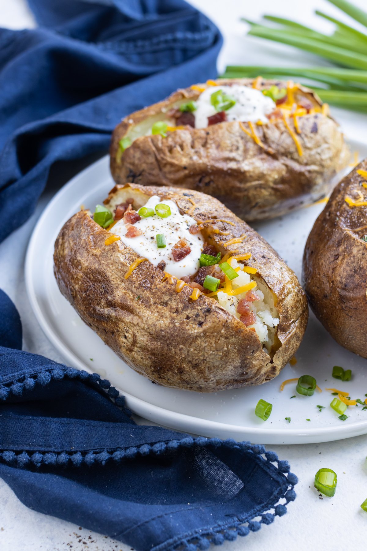 Serve baked potatoes with cheese, chives, and bacon.