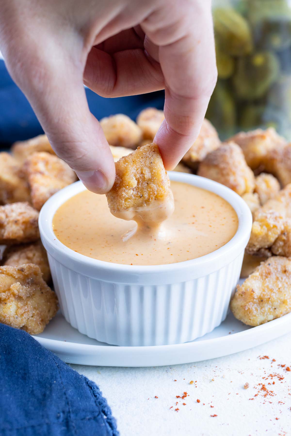 Dipping sauce is served beside chicken nuggets.
