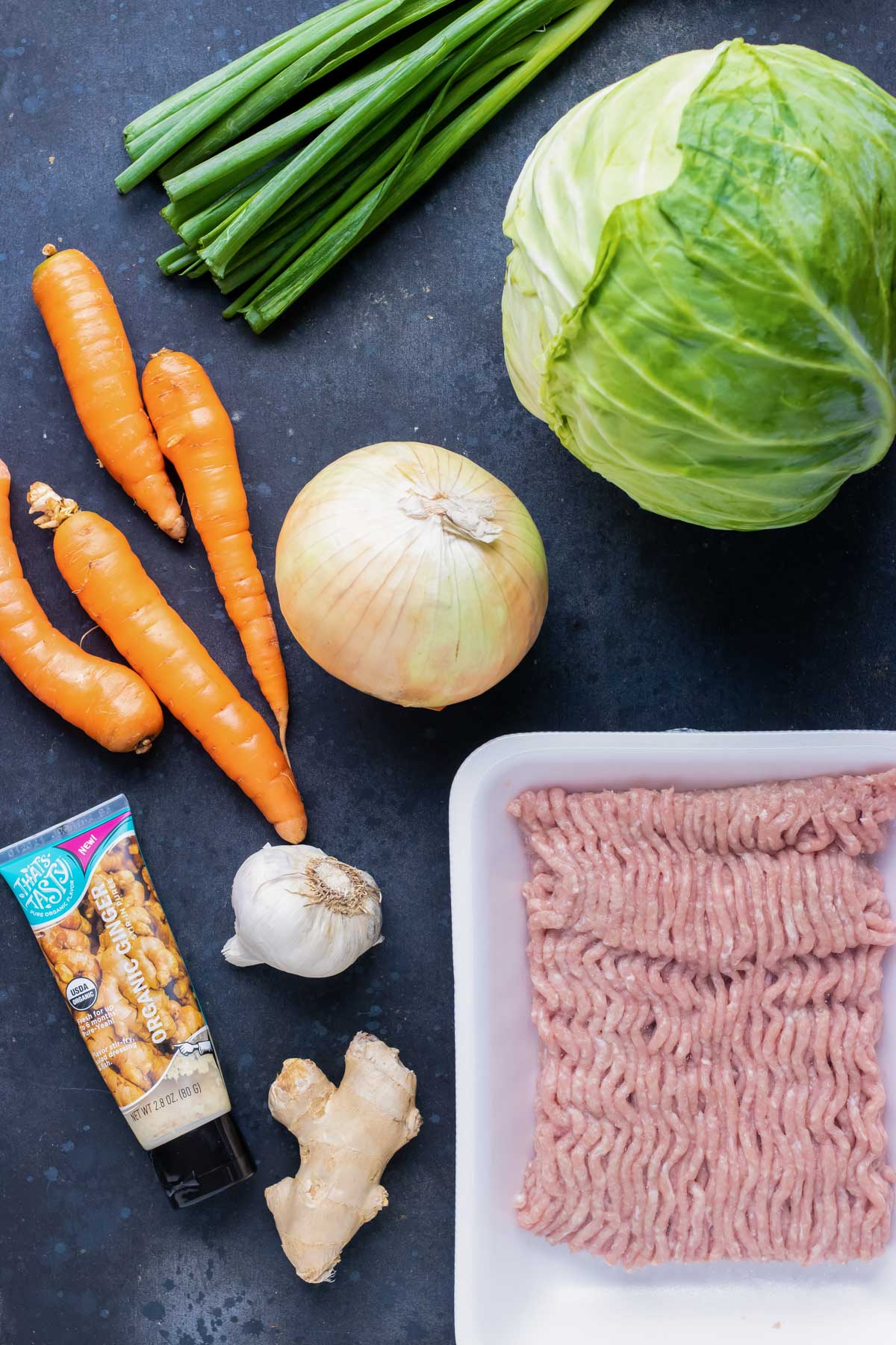 Cabbage, ground turkey, carrots, garlic, and ginger as the ingredients for an egg roll in a bowl recipe.