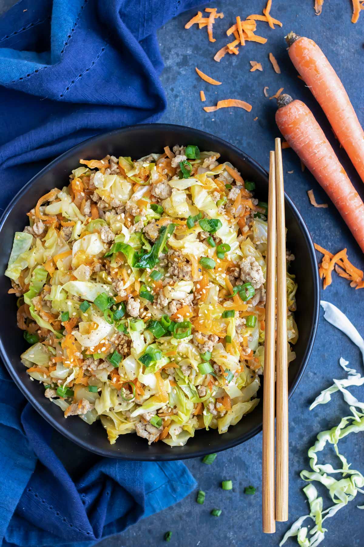 Keto and Paleo egg roll in a bowl dinner recipe with chopsticks and a blue napkin.