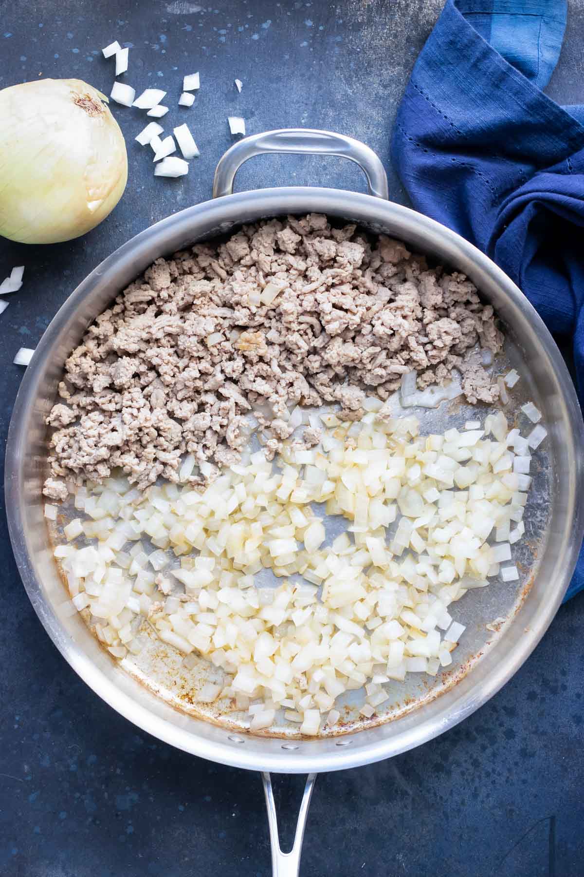 Cooked ground turkey and onion being sauteed in a skillet.