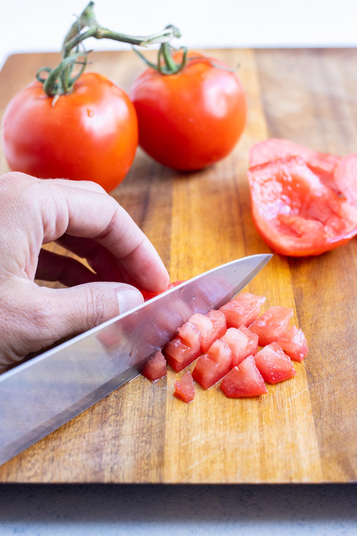 Tomato slices geting cut into small cubes.