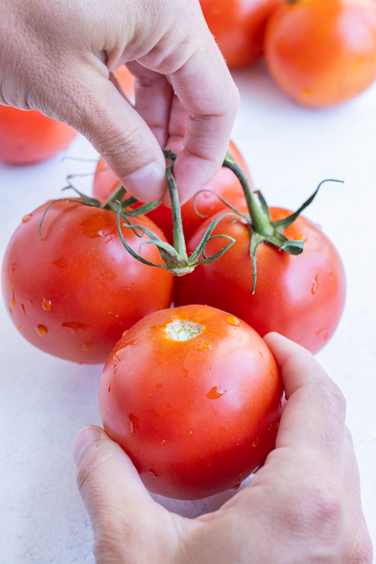 The stem is removed from three tomatoes