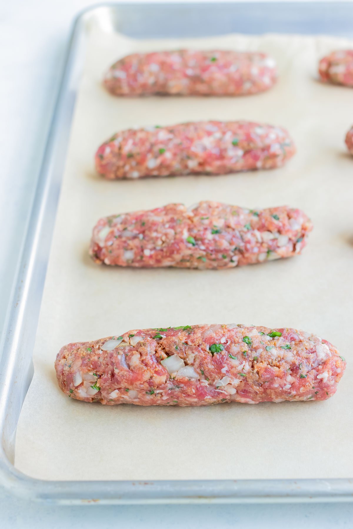 Lamb Kofta Kebabs are set on a baking sheet.