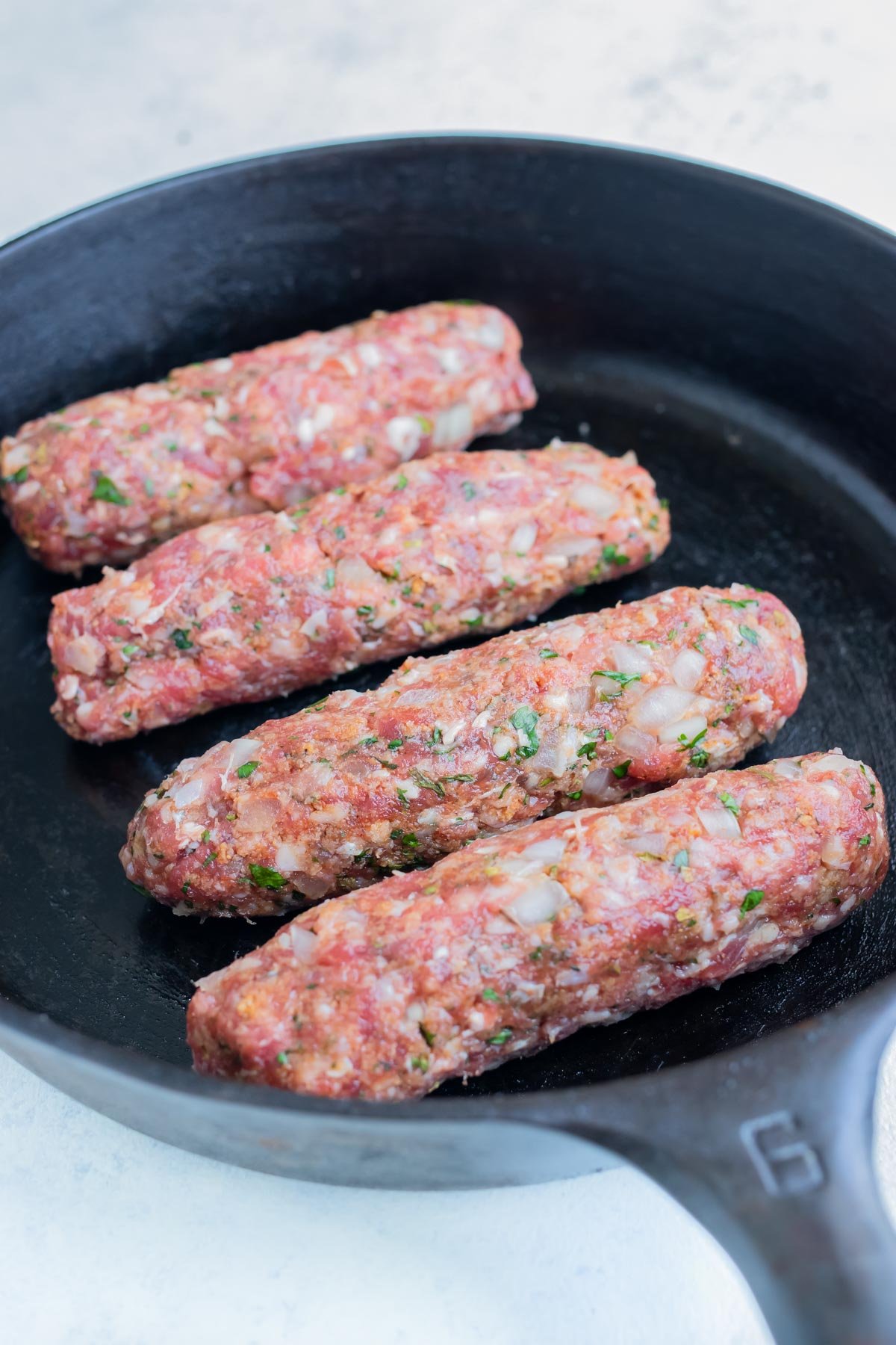 Lamb kofta is seared and cooked on the stove.