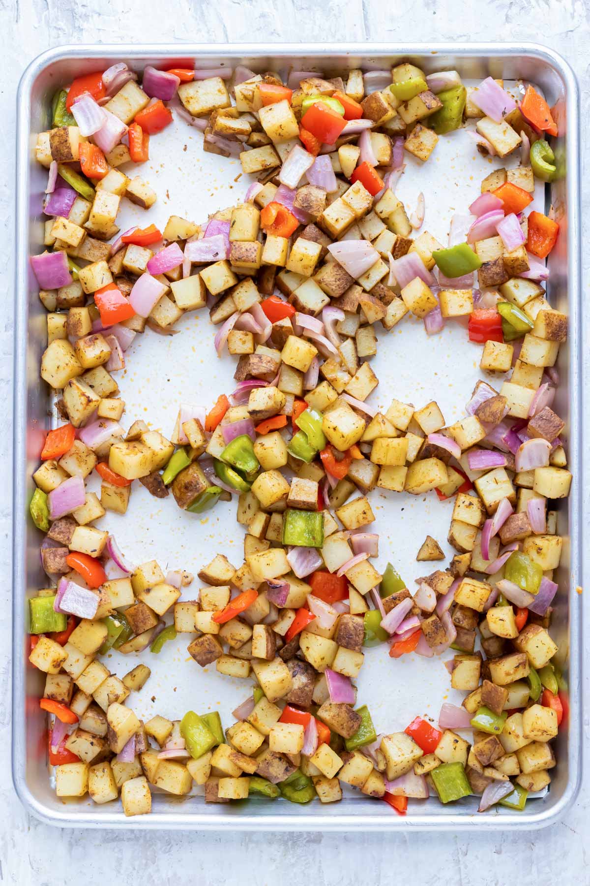 8 wells are made in a sheet pan with veggies