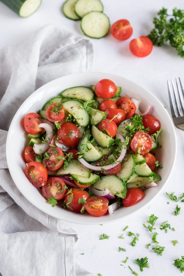 A bowl full of healthy cucumber tomato salad.