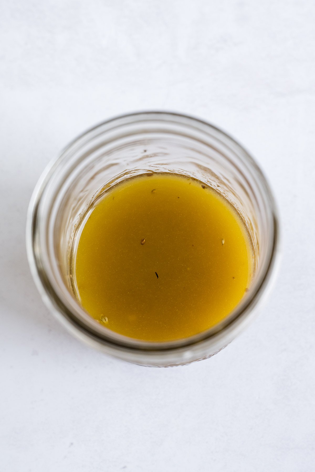 An overhead view of Greek dressing in a jar.