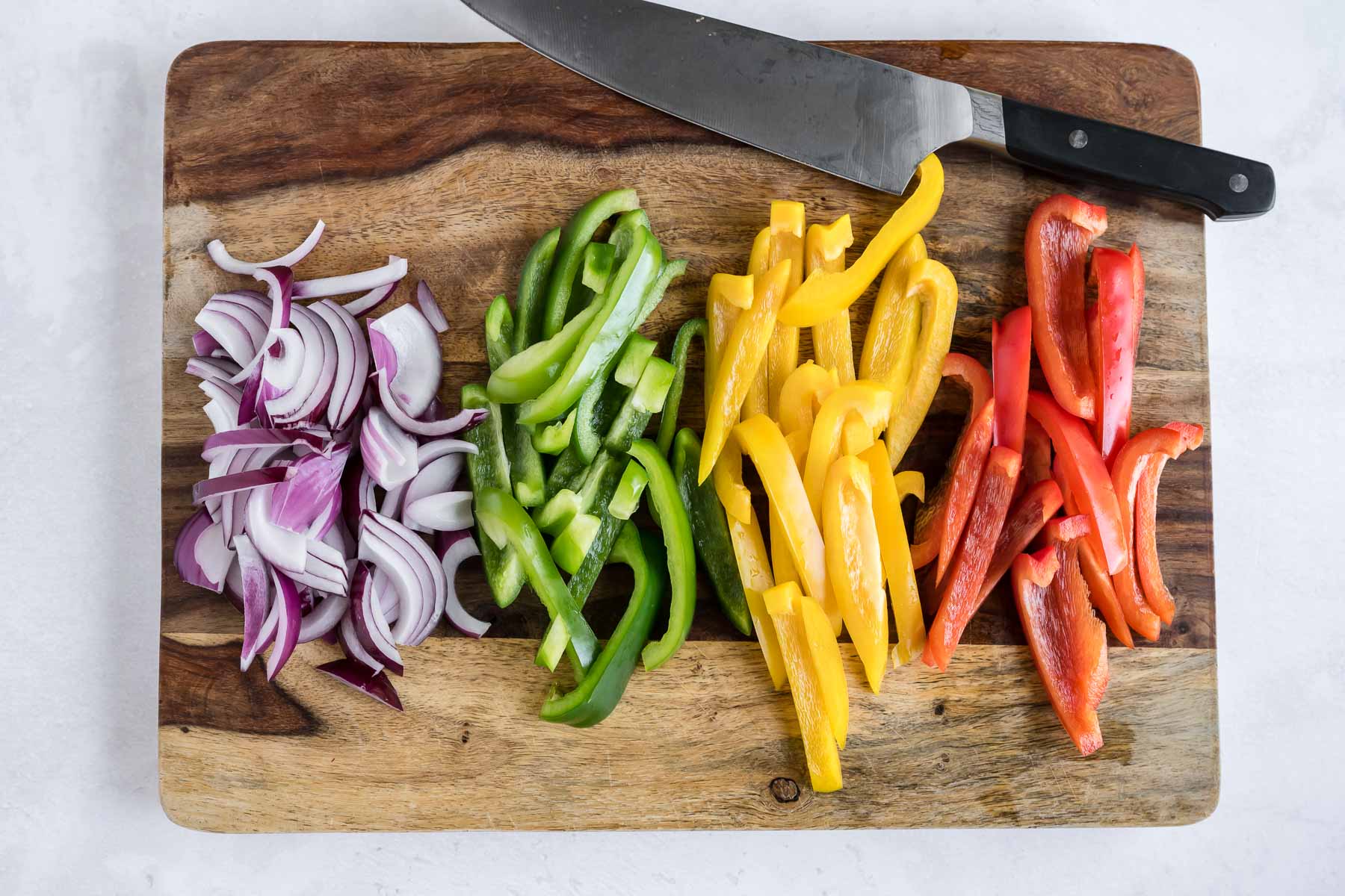 Onion and bell peppers are thinly sliced.