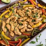 Chicken and veggies are cooked on a sheet pan together.