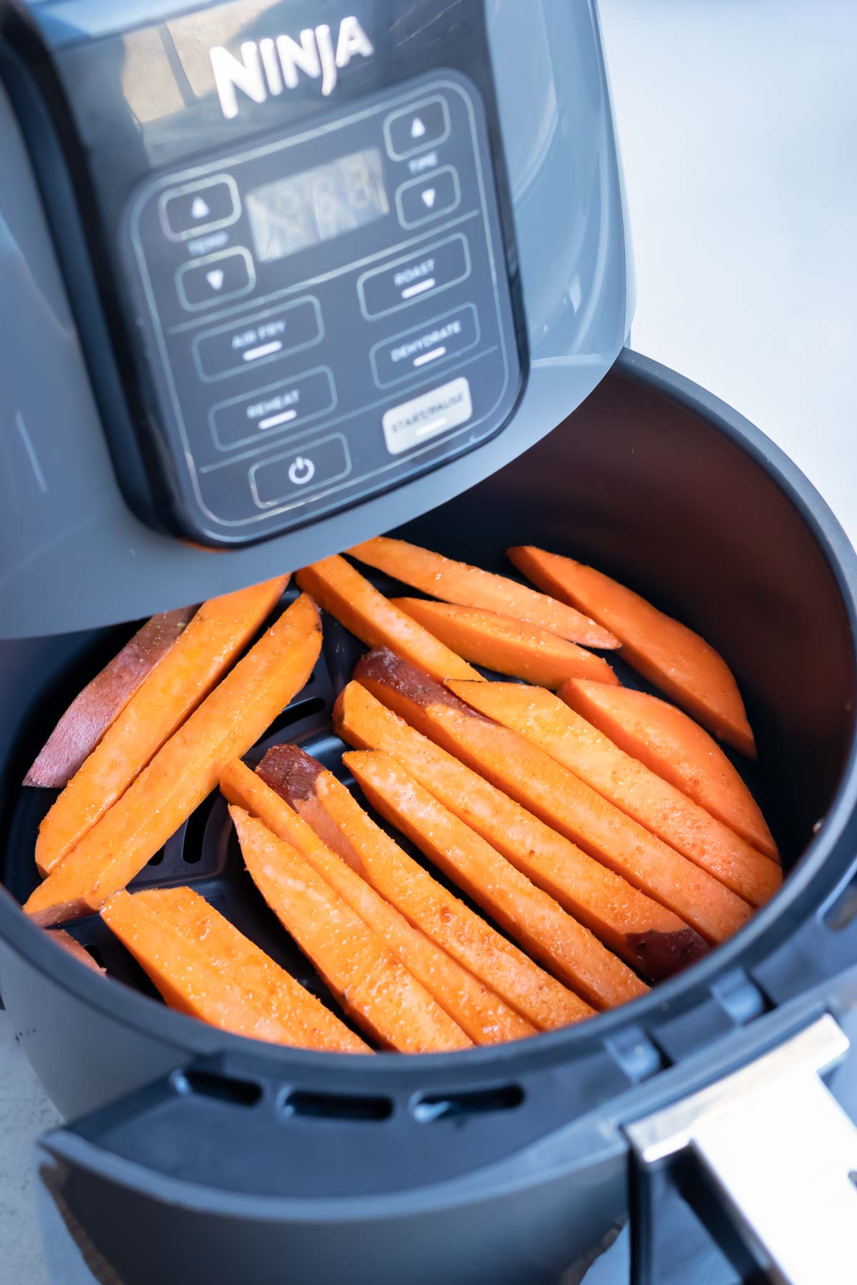 Sweet potatoes are laid in one layer in the air fryer.