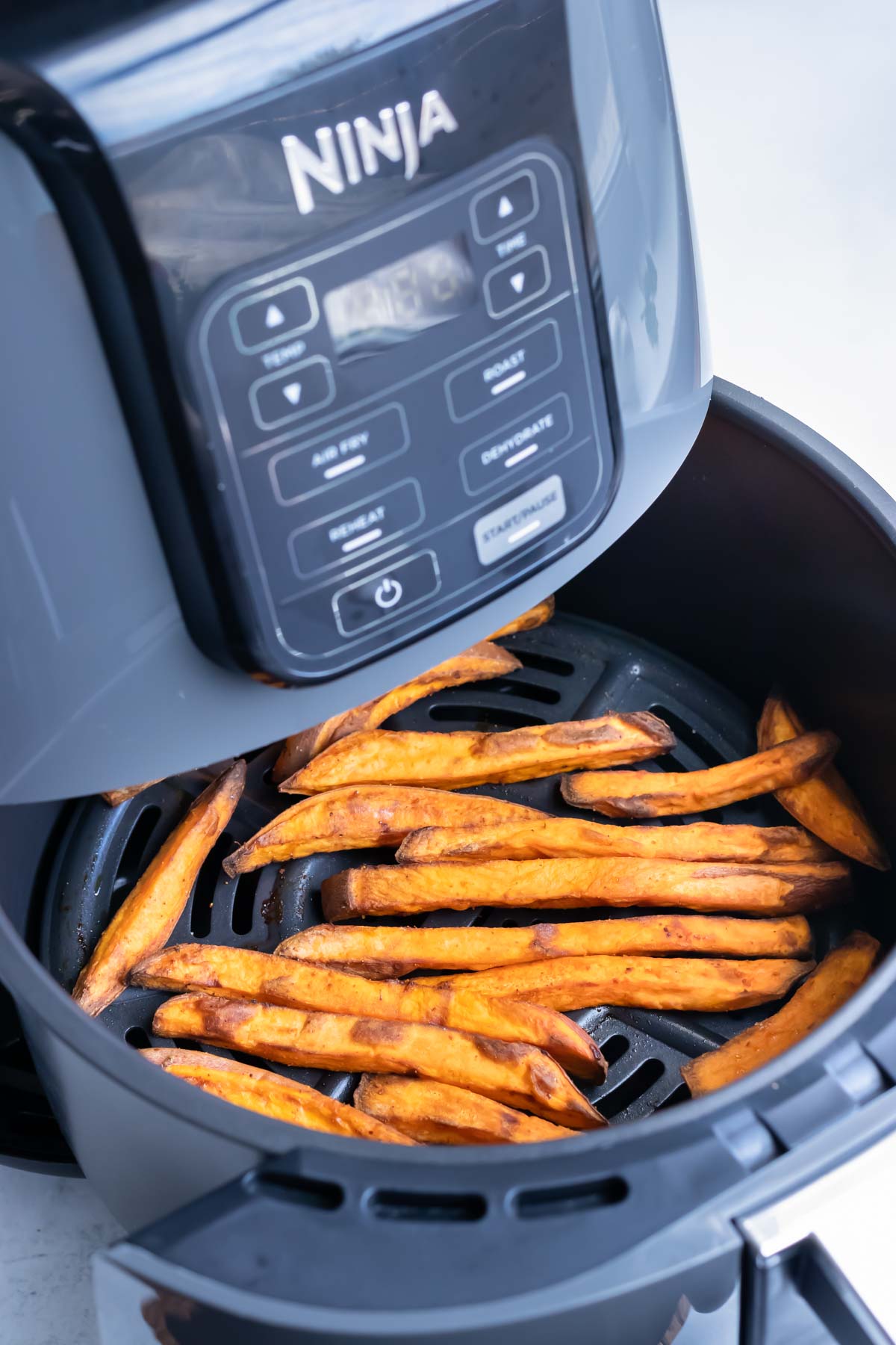 Sweet potato fries are placed in an air fryer.