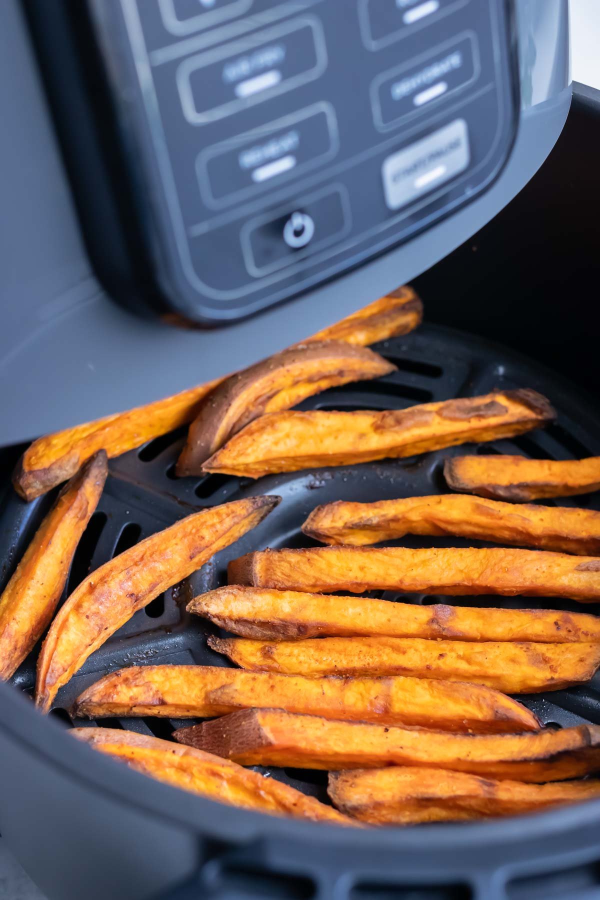 The crispy sweet potato fries are in one layer in the air fryer.