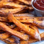 Crispy and healthy sweet potato fries made in your air fryer are served with ketchup.