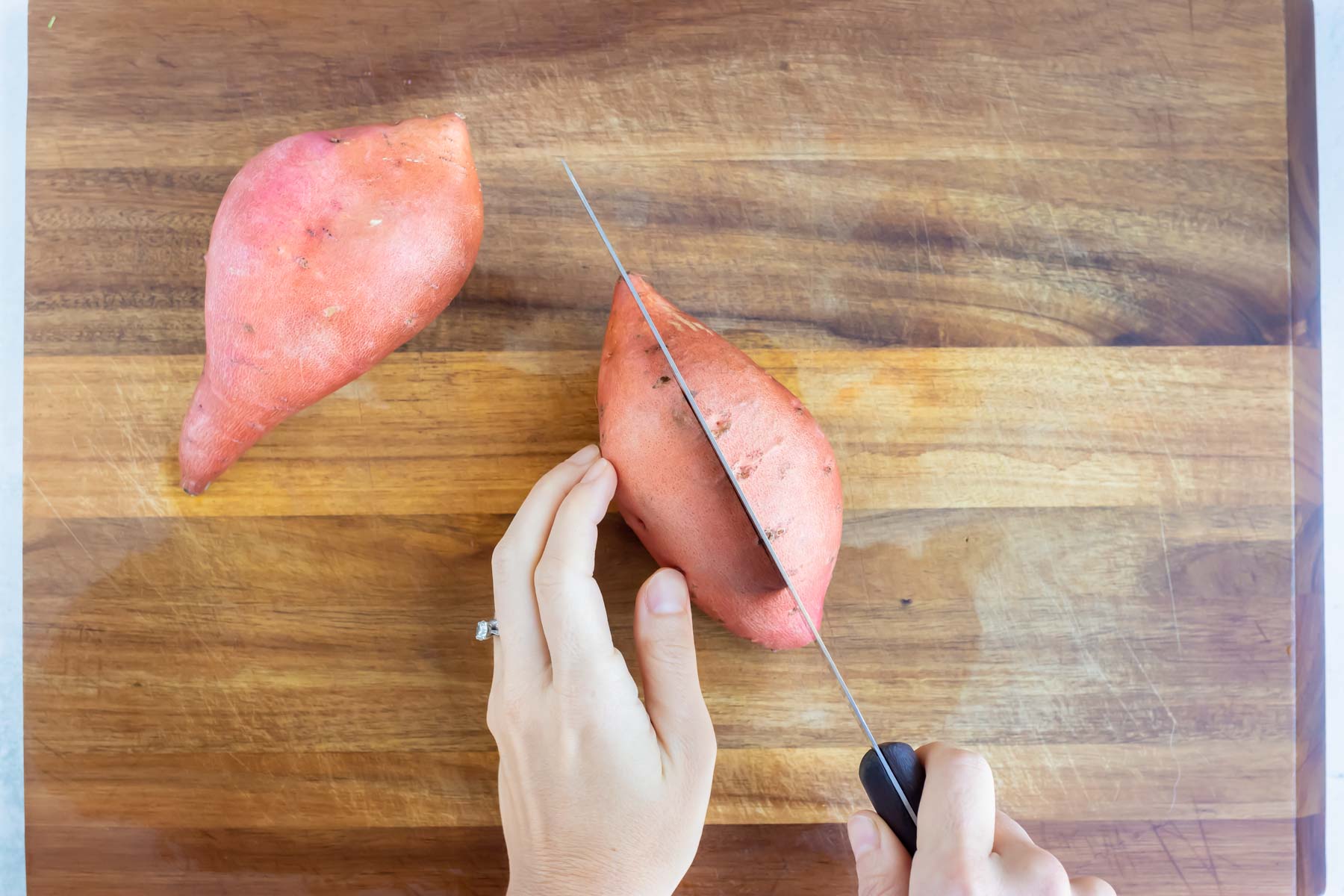 A raw sweet potato is cut in half.