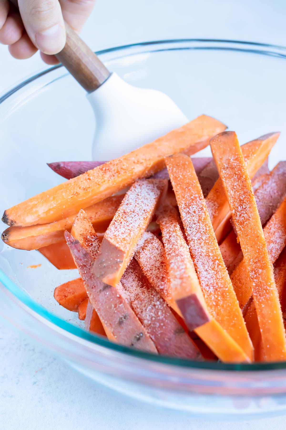 Salt, pepper, and seasonings are added to the sweet potatoes.