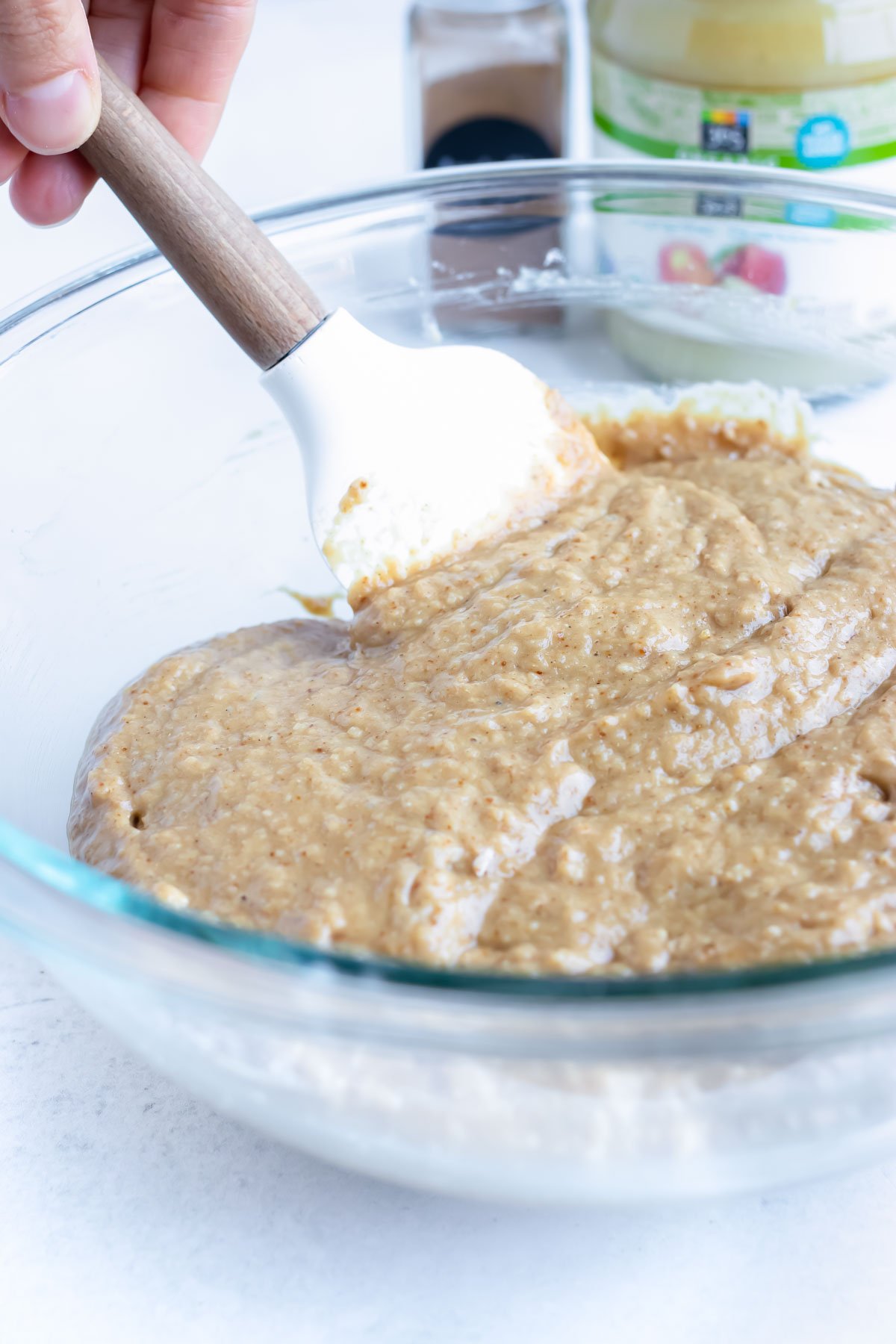 A spatula stirs the batter for applesauce muffins.