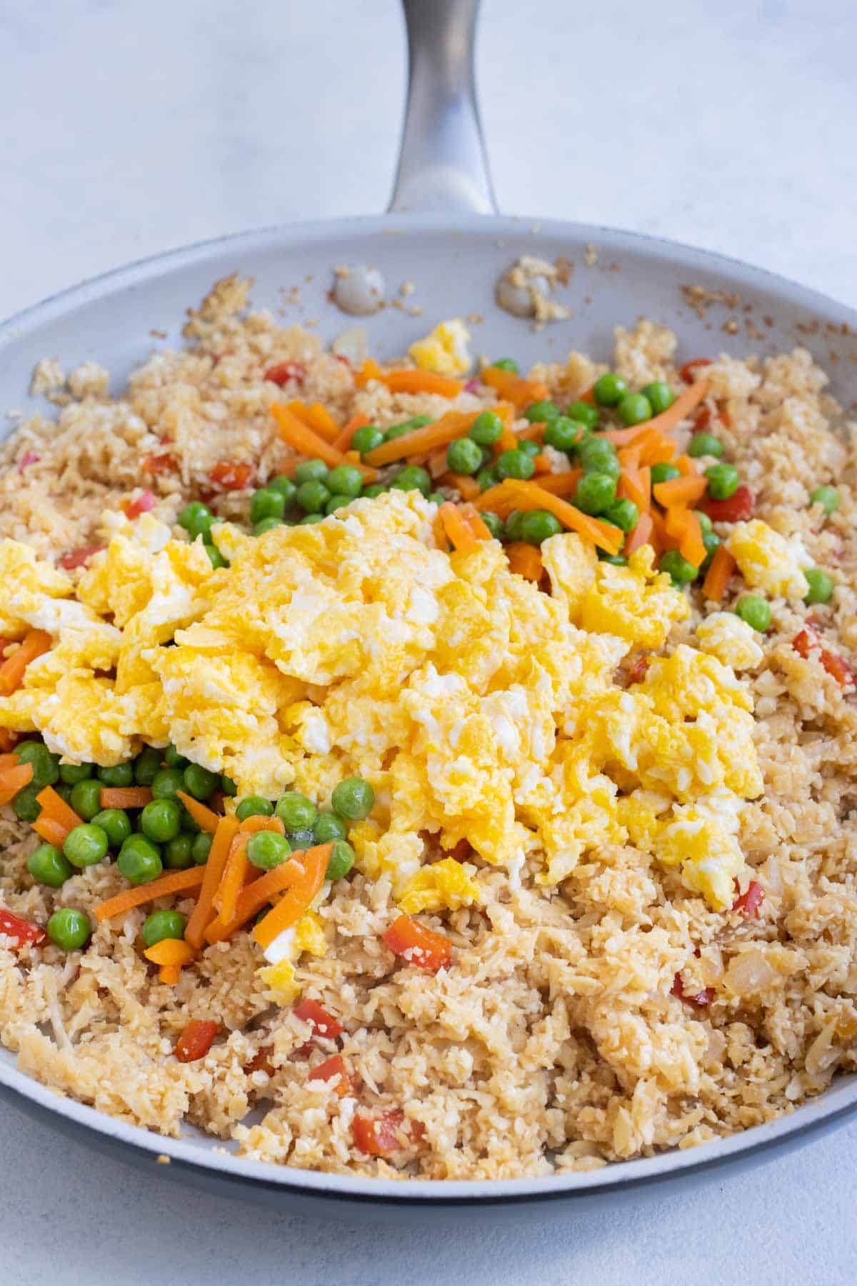 Scrambled eggs and thawed veggies are added back to the riced cauliflower.