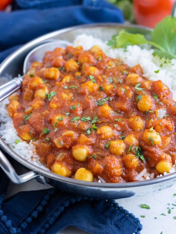 Chana masala is delicious with white rice and a sprig of cilantro.