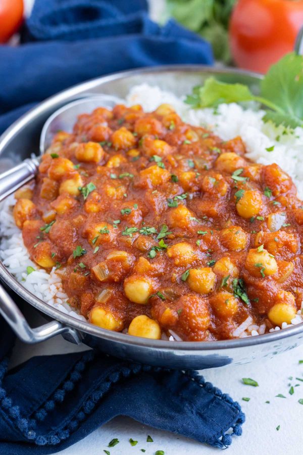 Chana masala is delicious with white rice and a sprig of cilantro.