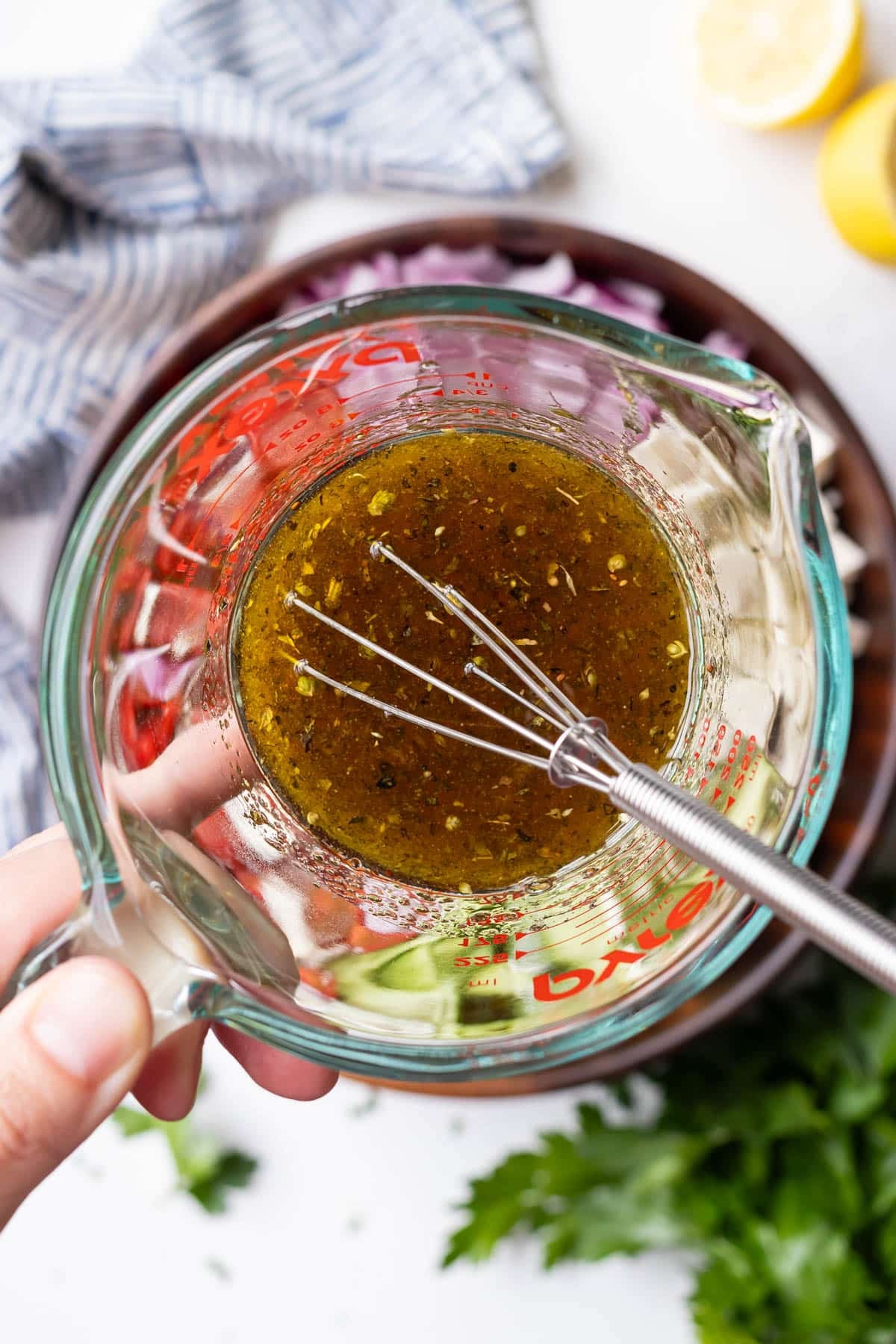 The Greek dressing is whisked together for a cucumber tomato and feta salad.