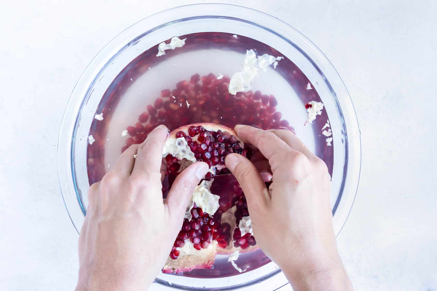 Using your hands, the seeds are removed from the pomegranate skin.