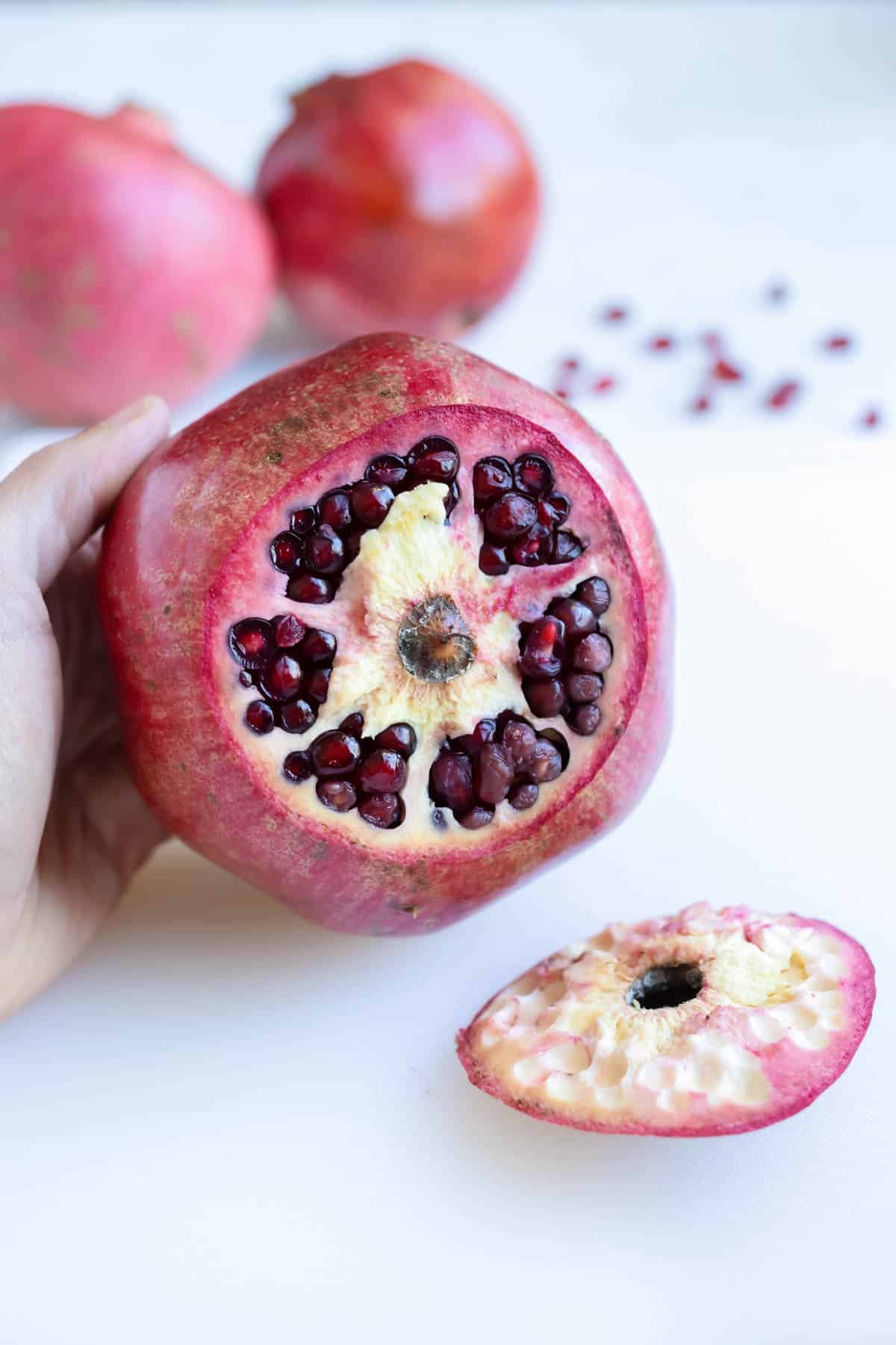 A pomegranate is cut open on the stem side.