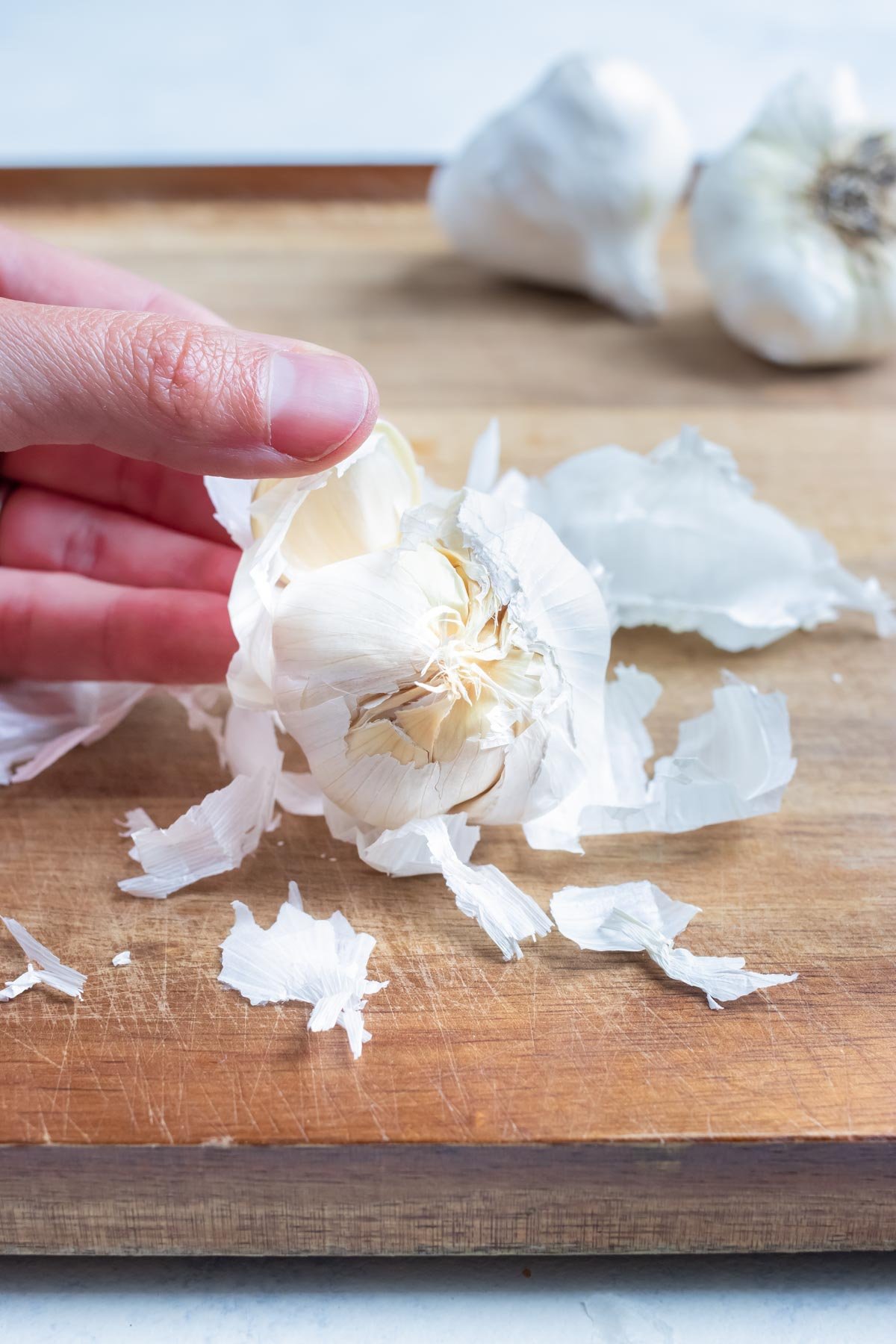 The skin is removed from the whole garlic bulb.
