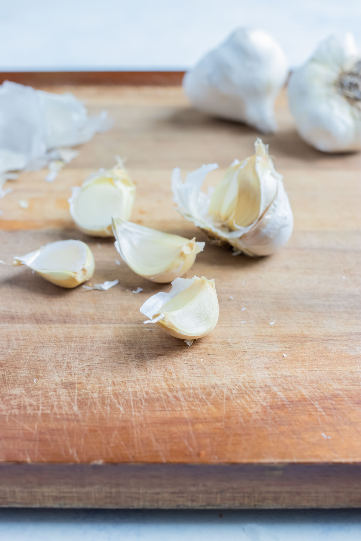 Multiple garlic cloves are shown on the counter.