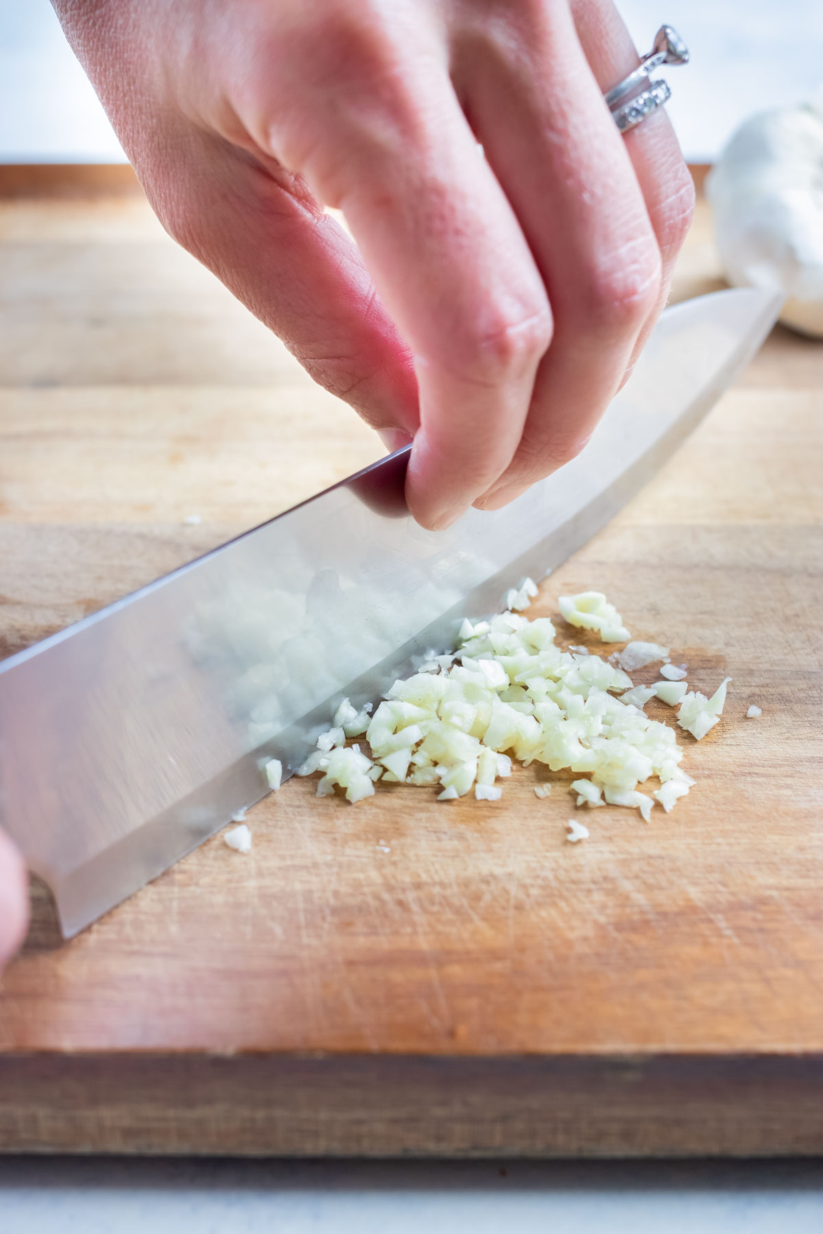 The garlic clove is then finely chopped with a chefs knife.