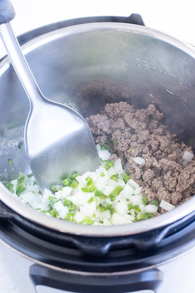 Diced onion and fresh jalapeños stirred into the browned beef for pressure cooker chili.
