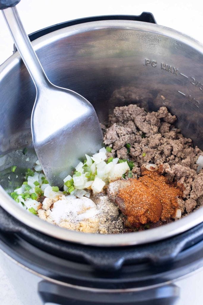 Homemade chili seasoning and tomato paste added to the beef in an Instant Pot.