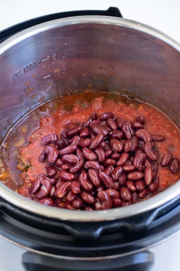 Crushed tomatoes and kidney beans layered on top of the meat so the Instant Pot chili doesn't scorch.