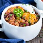 Instant Pot Turkey Chili in a white soup bowl with sour cream and cheese on top.