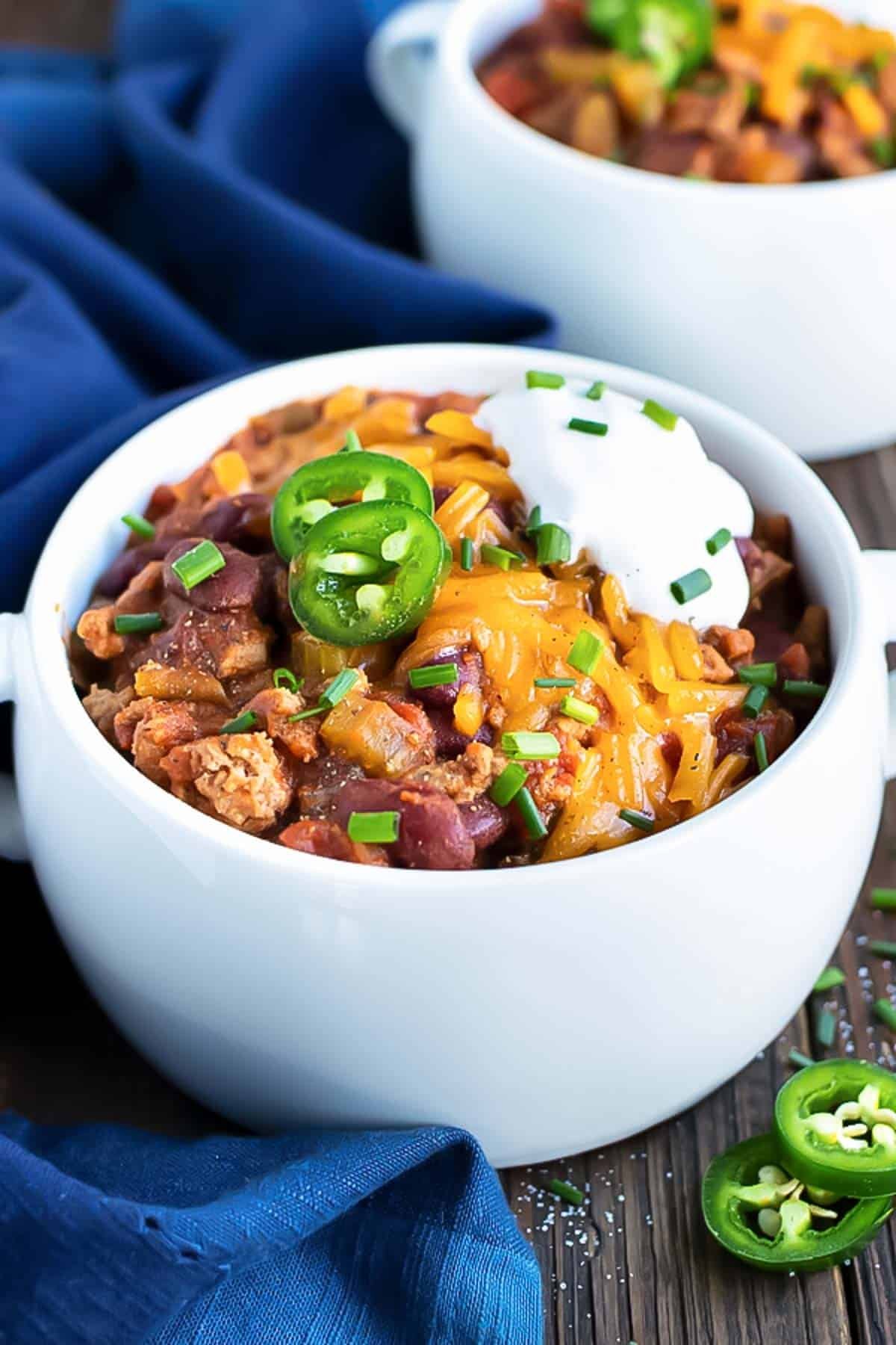 Instant Pot Turkey Chili in a white soup bowl with sour cream and cheese on top.