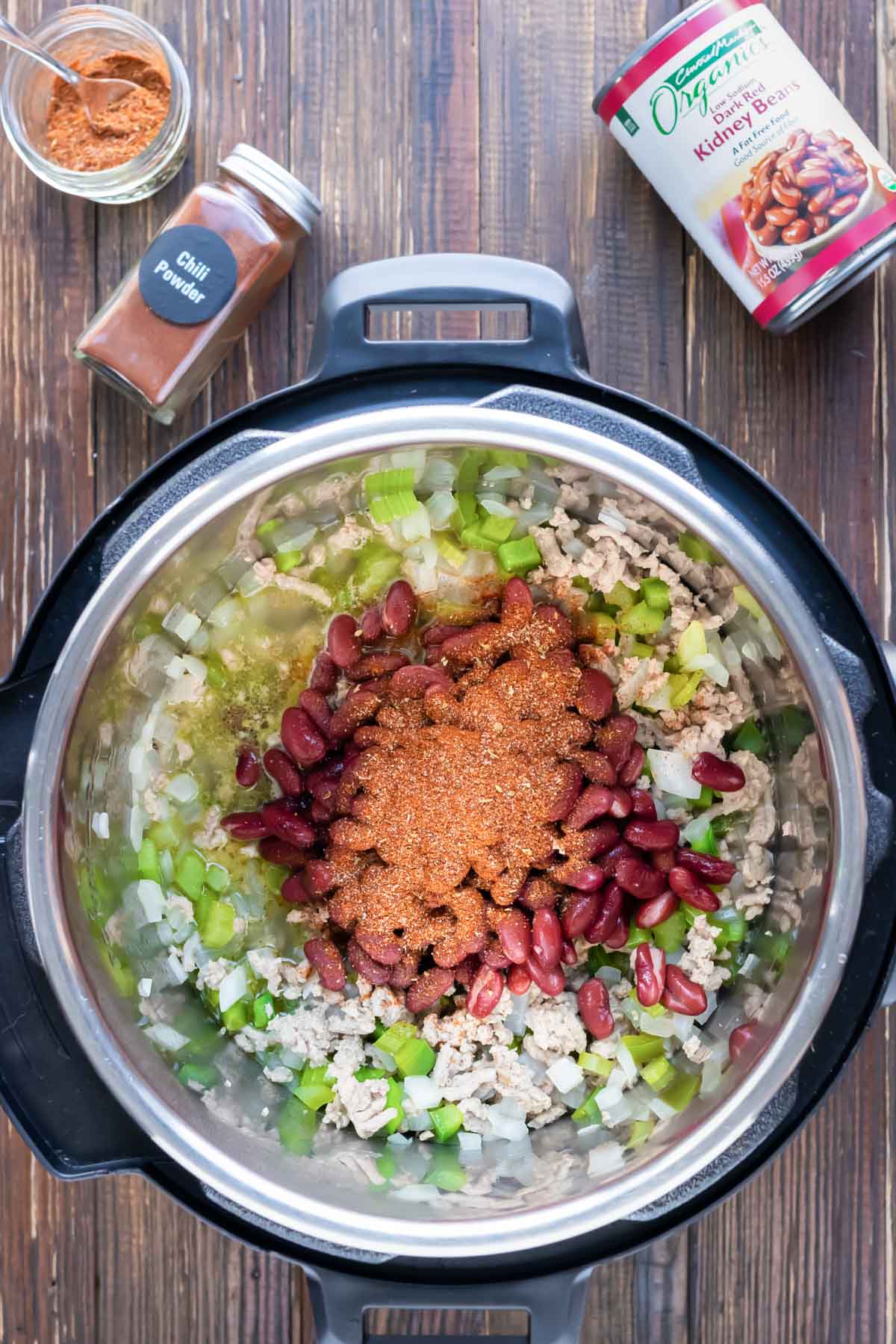 Seasoning and beans are combined in an Instant Pot with other ingredients.