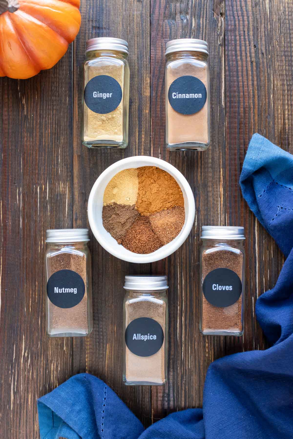Cinnamon, nutmeg, ginger, cloves, and allspice in a white bowl for a pumpkin spice recipe.