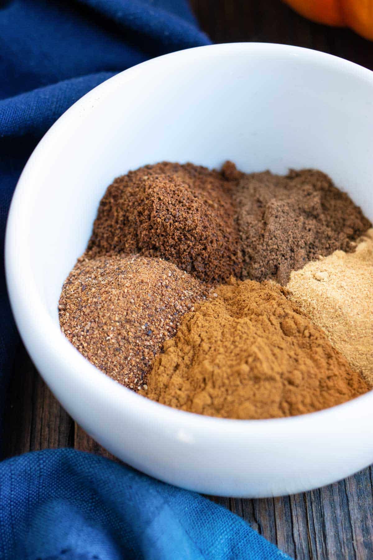 A white bowl showing all of the spices that go in pumpkin pie spice.