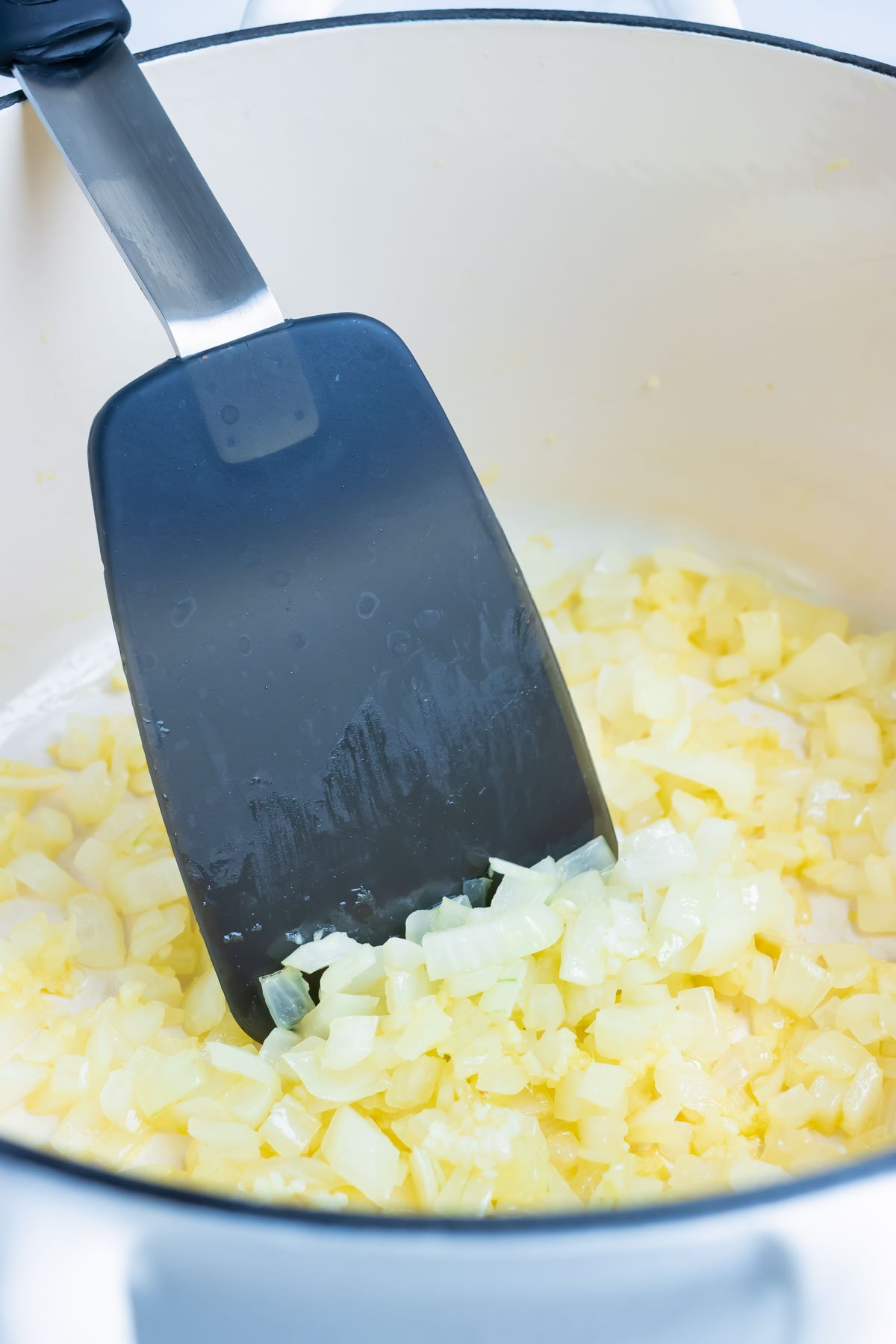 Onions are sautéed on the stove.