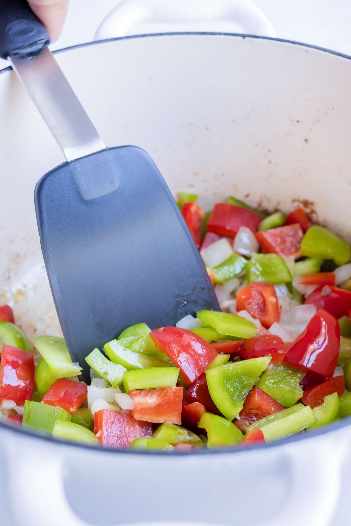 Bell peppers are added to the pot and cooked.