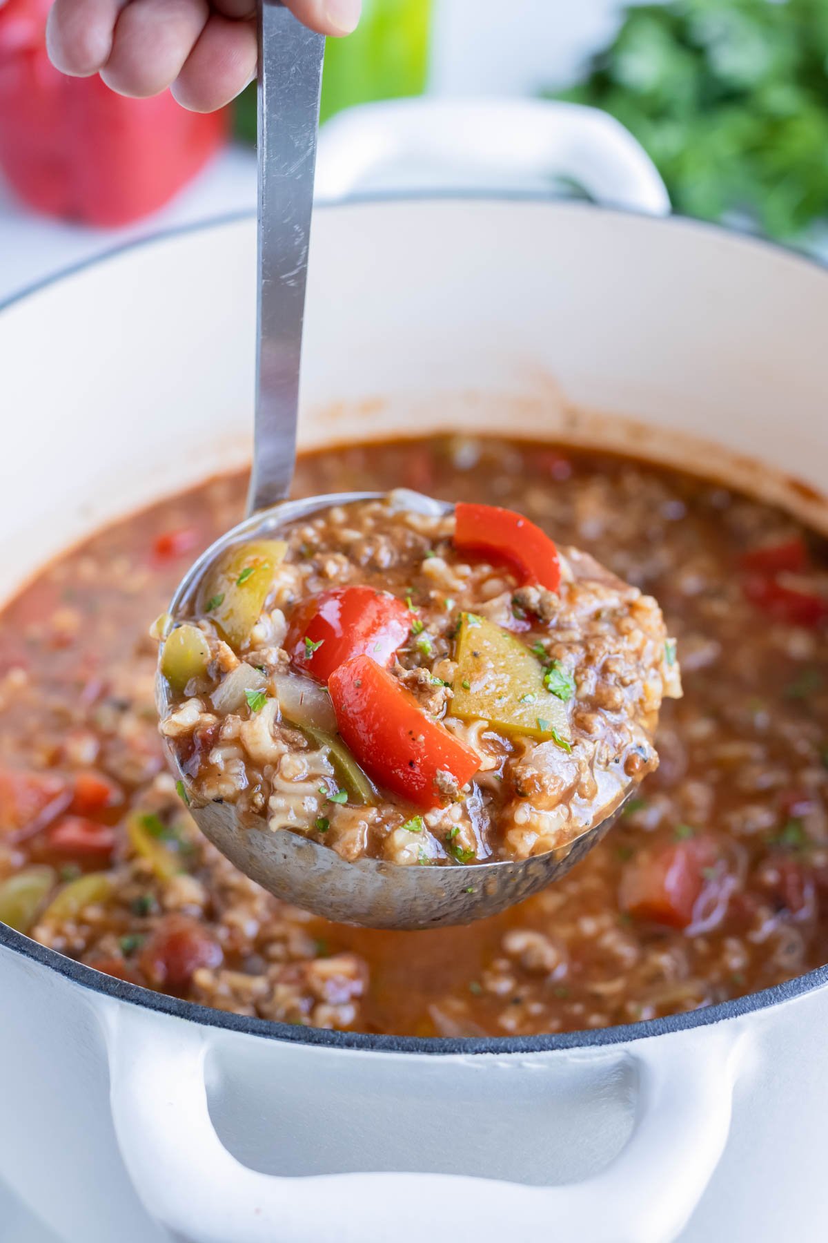 Stuffed pepper soup is served with a ladle.