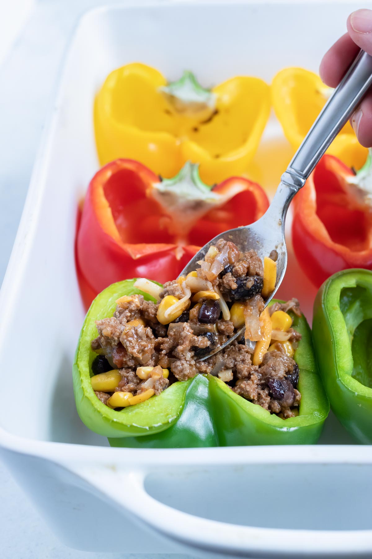 Cheese is added to the stuffed bell pepper filling.
