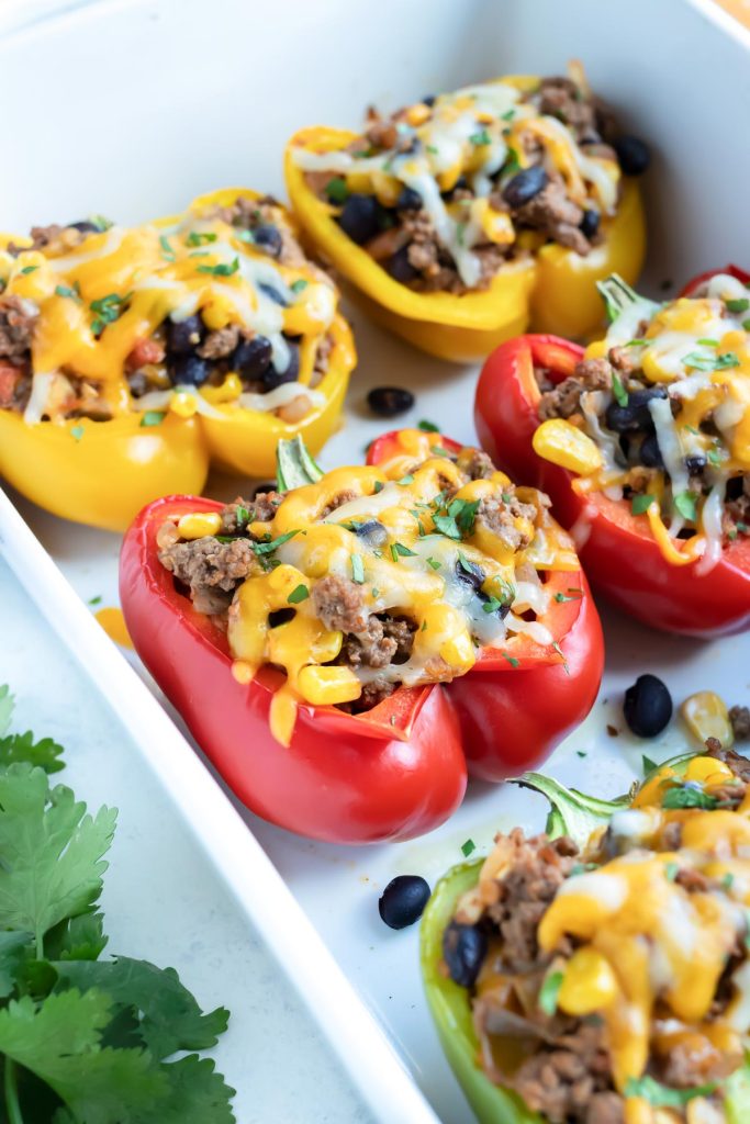 Ground beef Mexican stuffed peppers in a baking dish, ready to serve for a weeknight taco dinner.