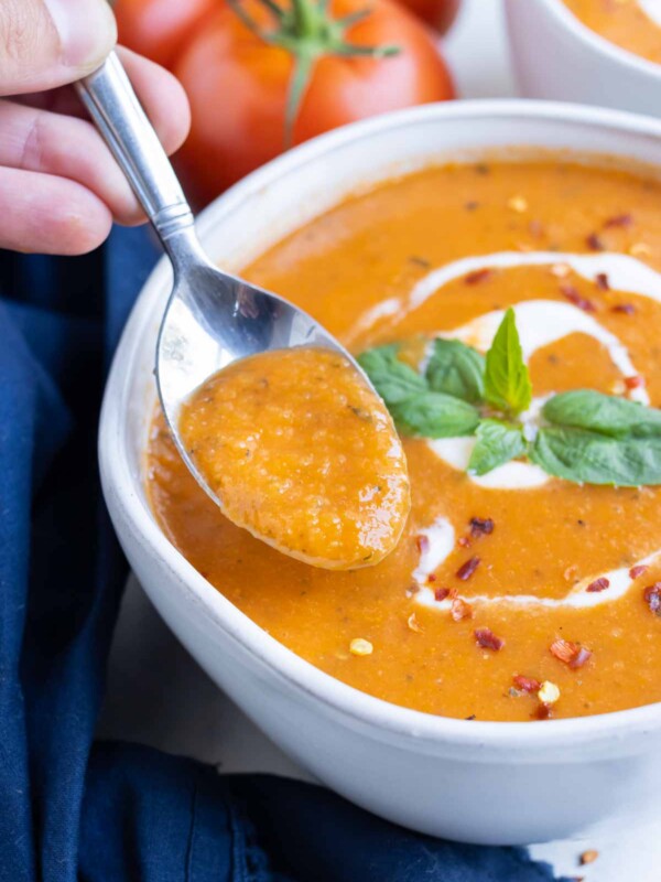 A white bowl is full of tomato basil bisque.