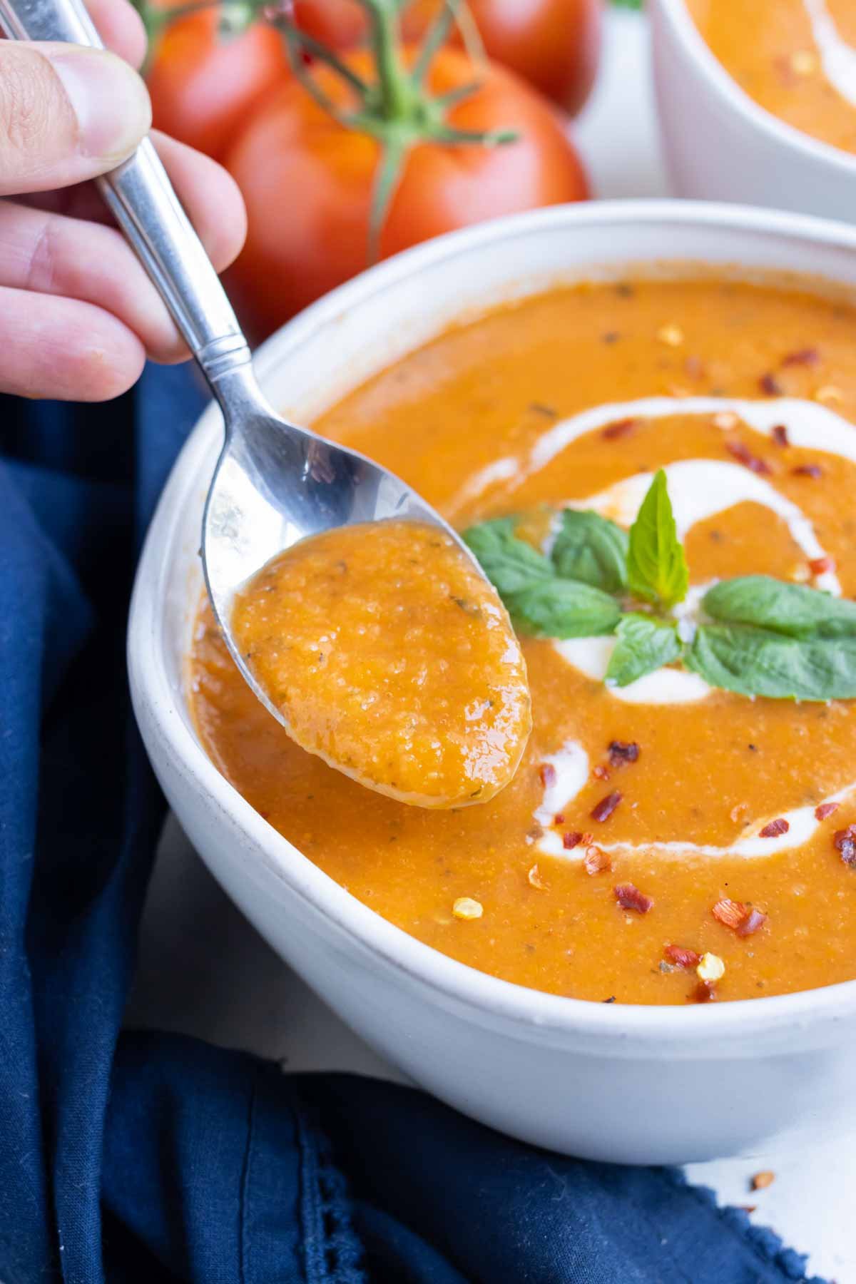 A white bowl is full of tomato basil bisque.