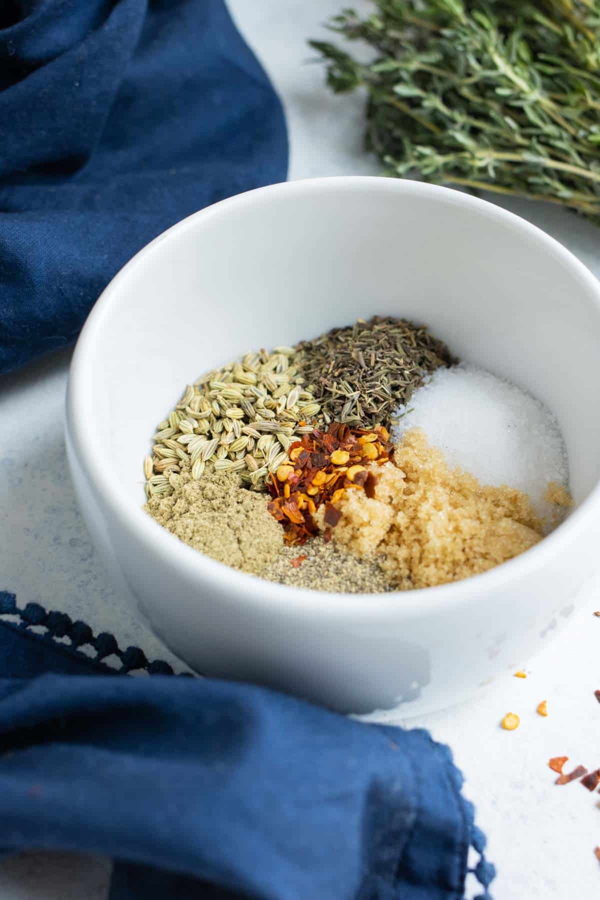 A white bowl is full of the ingredients need for this spice blend.