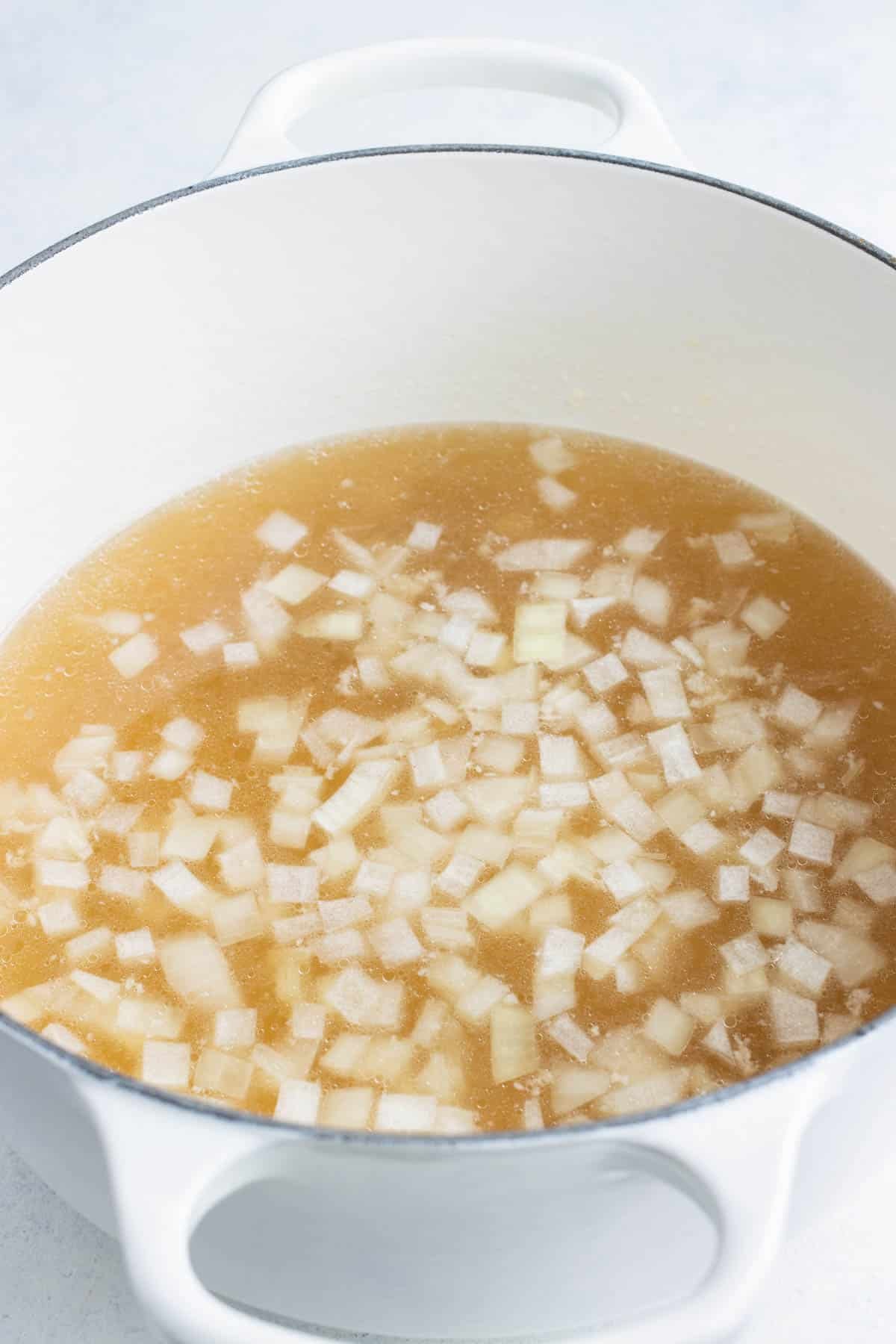 Broth and onions cook together.