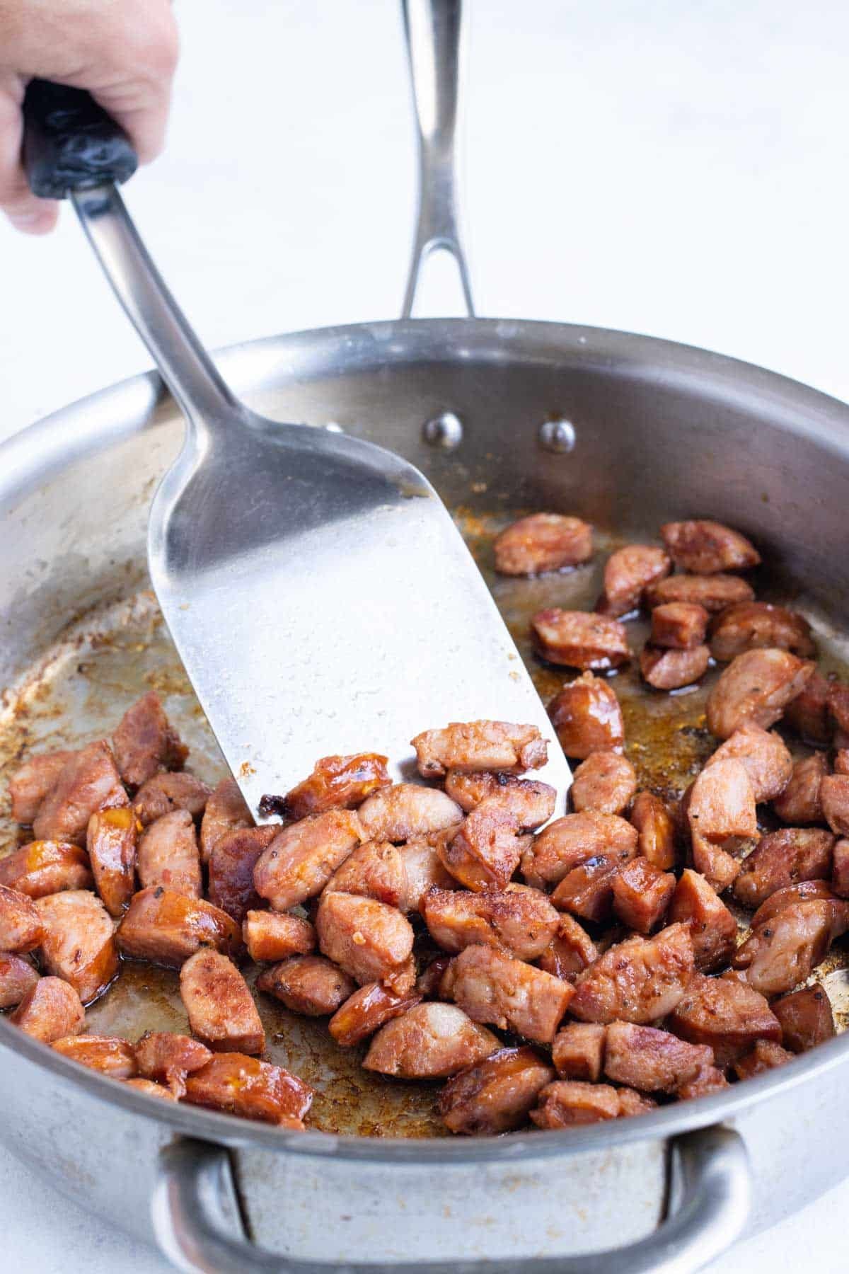 Sausage is cooked in a skillet.