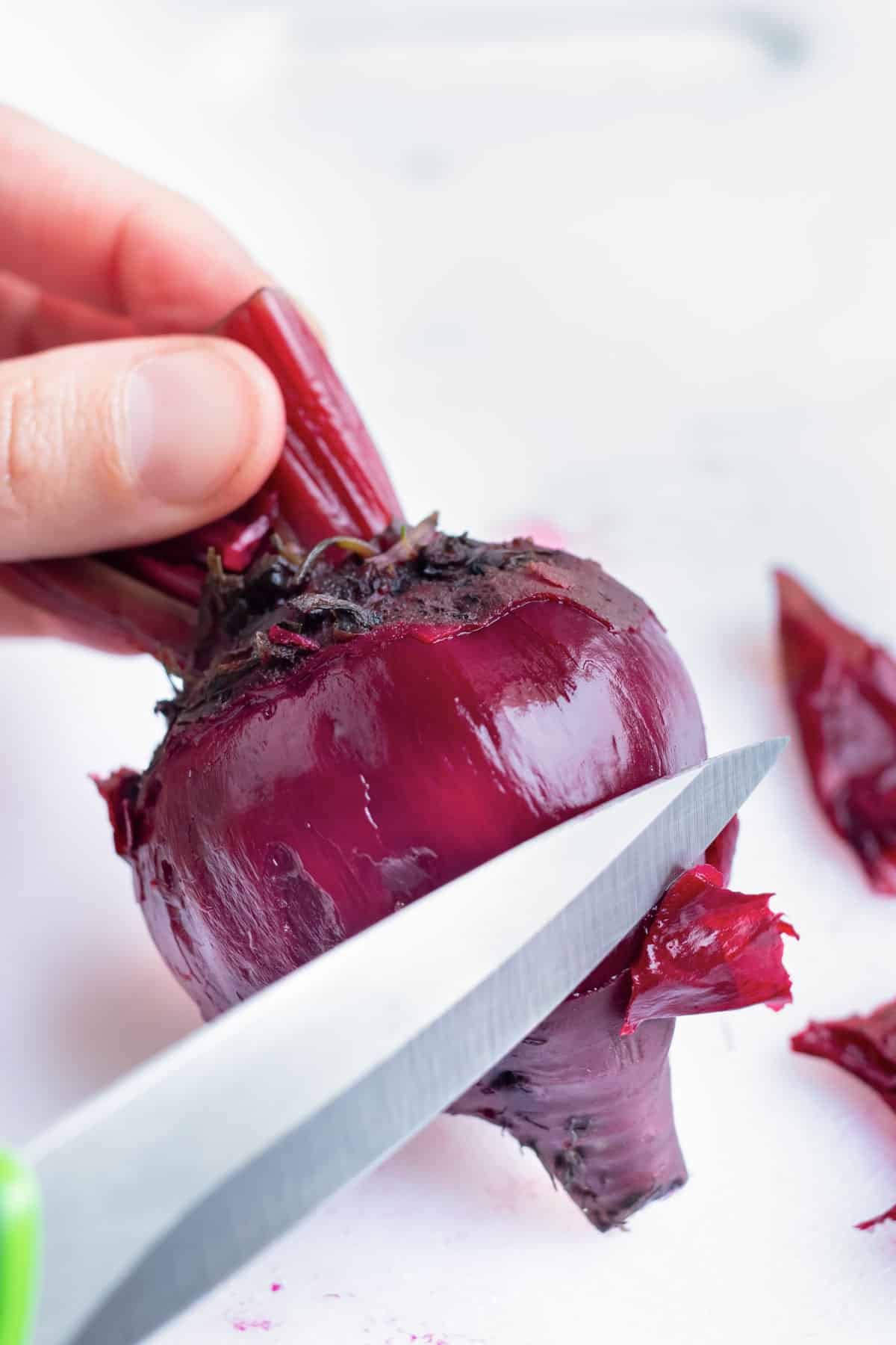 Whole beets are peeled with a pairing knife.